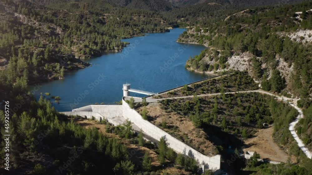 Dam reservoir on blue lake in mountain forest region in wild nature landscape France. Modern barrage on water produce generate alternative electricity from planet resources. Hydropower plant. Dam reservoir on blue lake in mountain forest region in wild nature landscape France. Modern barrage on water produce generate alternative electricity from planet resources. Hydropower plant.