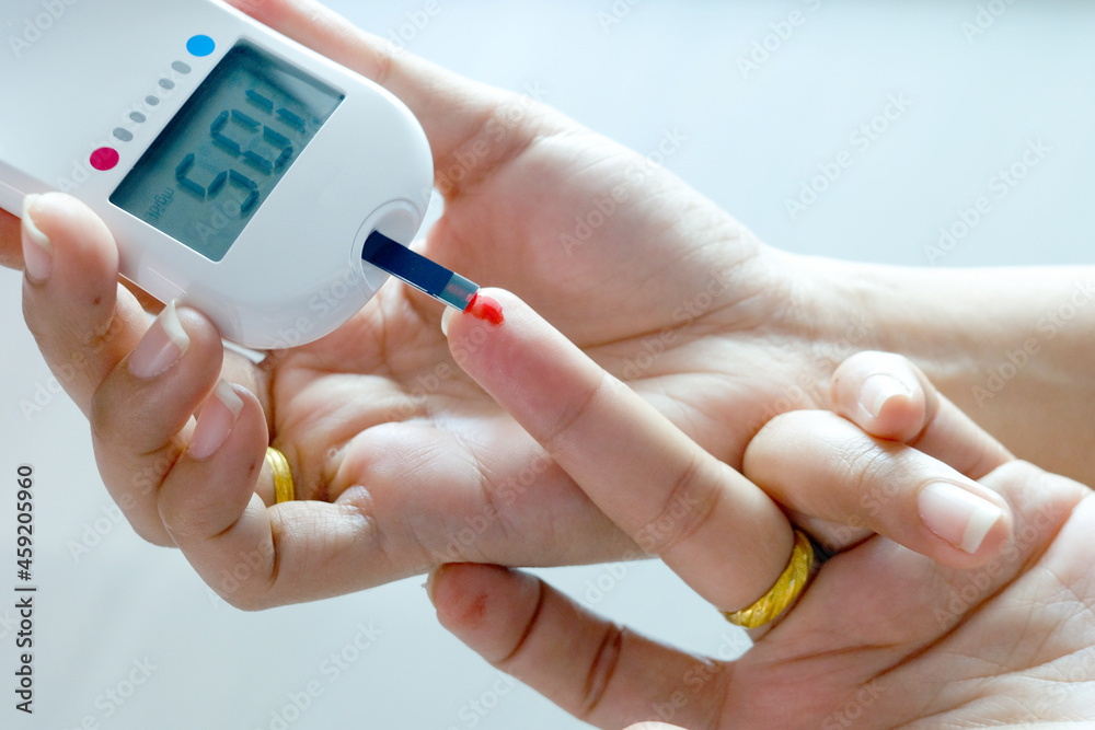 hand of people check diabetes and high blood glucose monitor with digital pressure gauge. Healthcare and Medical concept hand of people check diabetes and high blood glucose monitor with digital pressure gauge. Healthcare and Medical concept