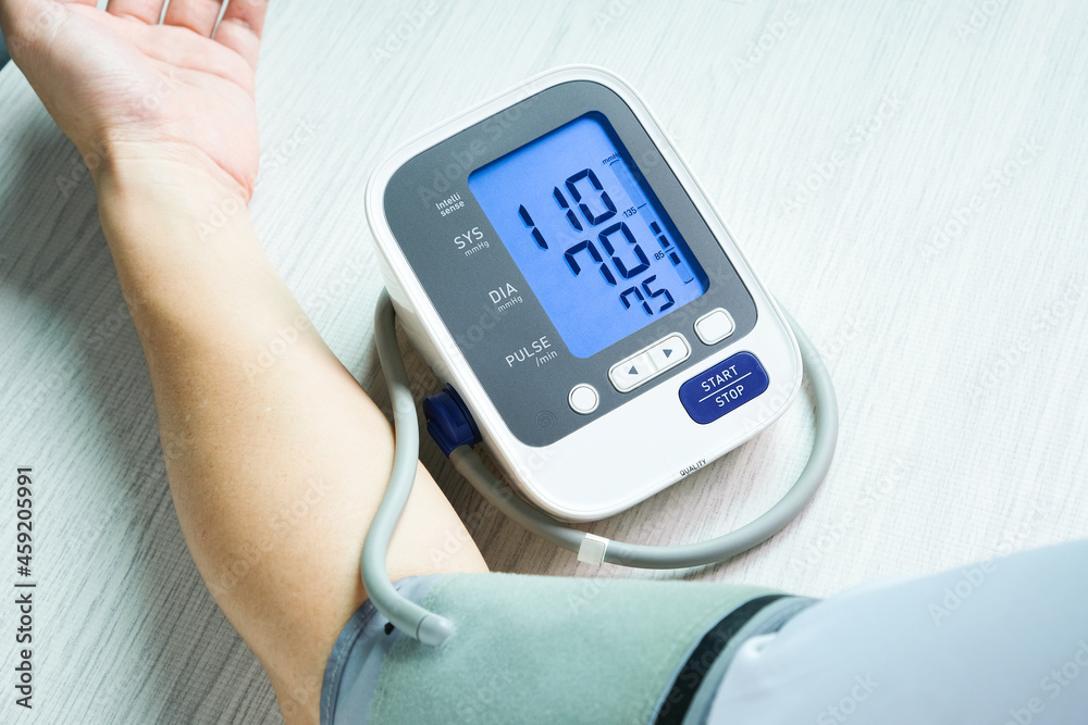 Man check blood pressure monitor and heart rate monitor with digital pressure gauge. Health care and Medical concept Man check blood pressure monitor and heart rate monitor with digital pressure gauge. Health care and Medical concept