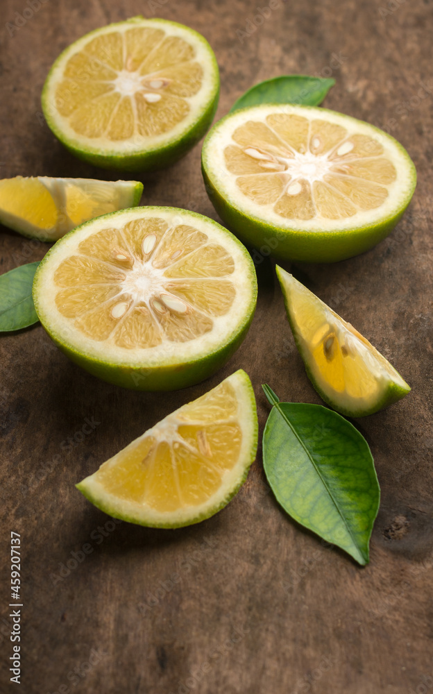 sweet oranges, fruit slices with green leaves on wooden table top, background with copy space sweet oranges, fruit slices with green leaves on wooden table top, background with copy space
