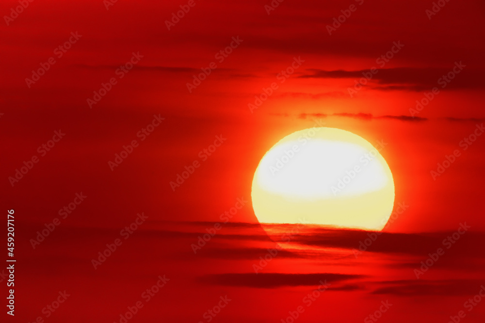 Bright warm sun on sky background. Dawn or sunset.