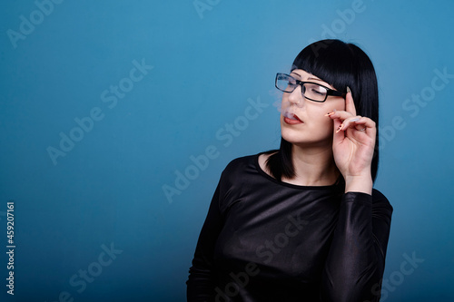 portrait of a beautiful girl with glasses posing for a photographer in the studio