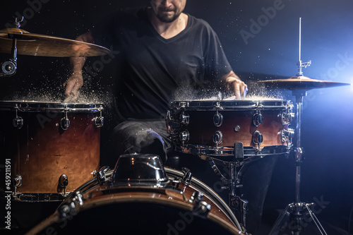Sticker A male drummer plays snare drum with drumsticks in a dark room.