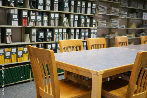 close up on table and chair in the library in front of book shelves
