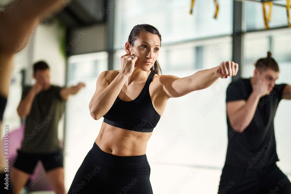 Ταπετσαρία Young sportswoman exercises hand punches during martial arts training at health club