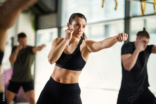 Young sportswoman exercises hand punches during martial arts training at health club. photo