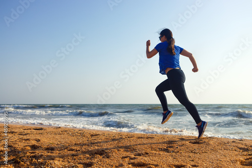 woman running by the sea beach in the morning