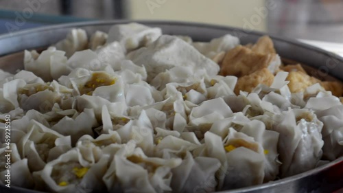 pile of dumplings in a steaming pot with steaming steam. healthy traditional food dumplings, tofu and fish balls