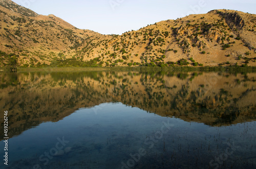 Mountain lake landscape with reflection in water at sunrise