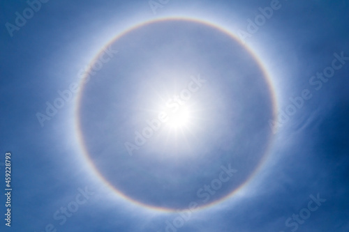 The sun shines brightly in the sky and natural phenomenon called circumscribed halo photo
