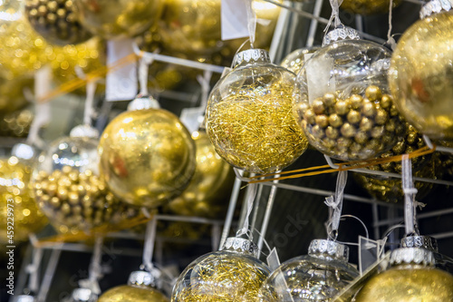 Christmas ball hangs on a shelf in the store among other Christmas toys