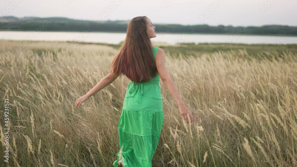 free girl walk fun across field in the park. free dream concept. girl whirls hands to sides walk across the field. happy free lifestyle girl walking in park nature land free girl walk fun across field in the park. free dream concept. girl whirls hands to sides walk across the field. happy free lifestyle girl walking in park nature land
