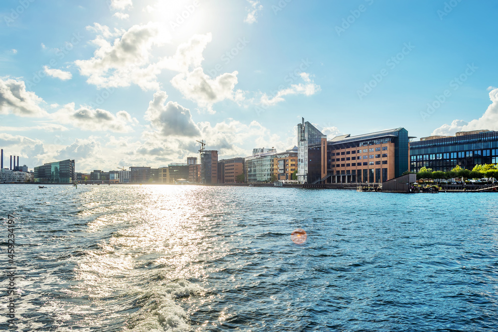Naklejka premium Beautiful modern buildings on the bank of the canal in Copenhagen, Denmark.Sun, beautiful clouds. Contemporary European architecture. Architecture.