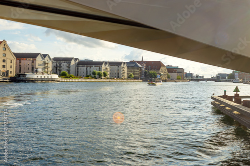 Beautiful modern buildings on the bank of the canal in Copenhagen, Denmark.View from the water, from under the bridge. Contemporary European architecture. © vallerato
