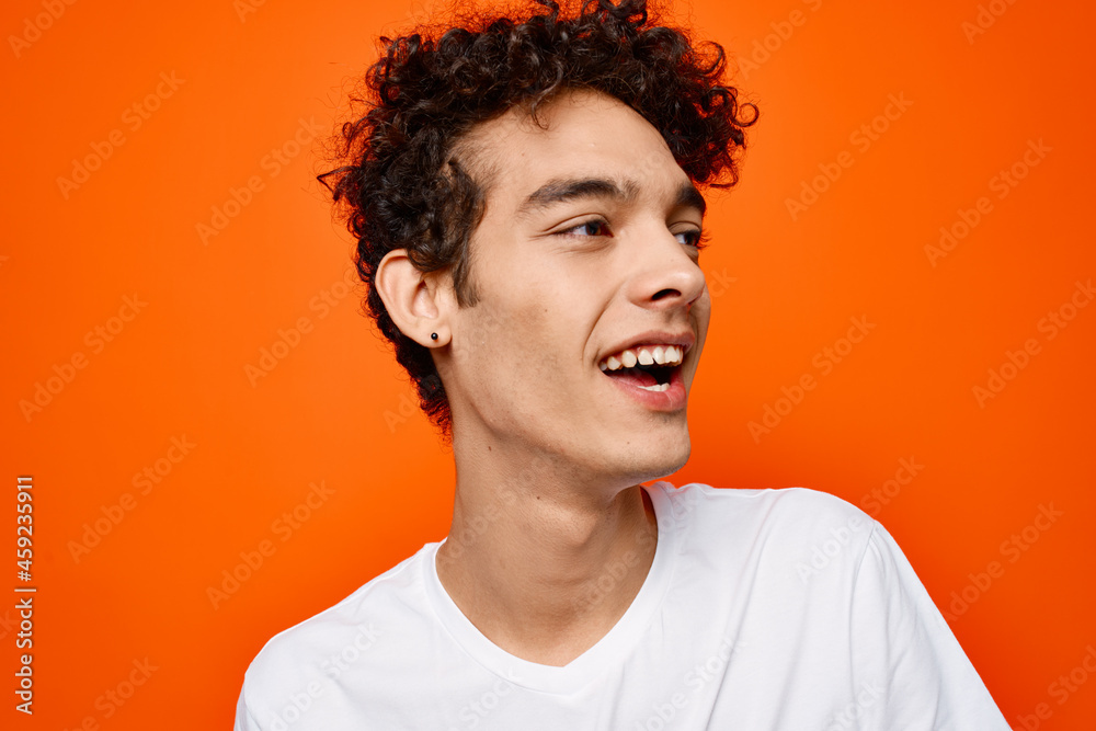 man in white t-shirt curly hair orange background man in white t-shirt curly hair orange background