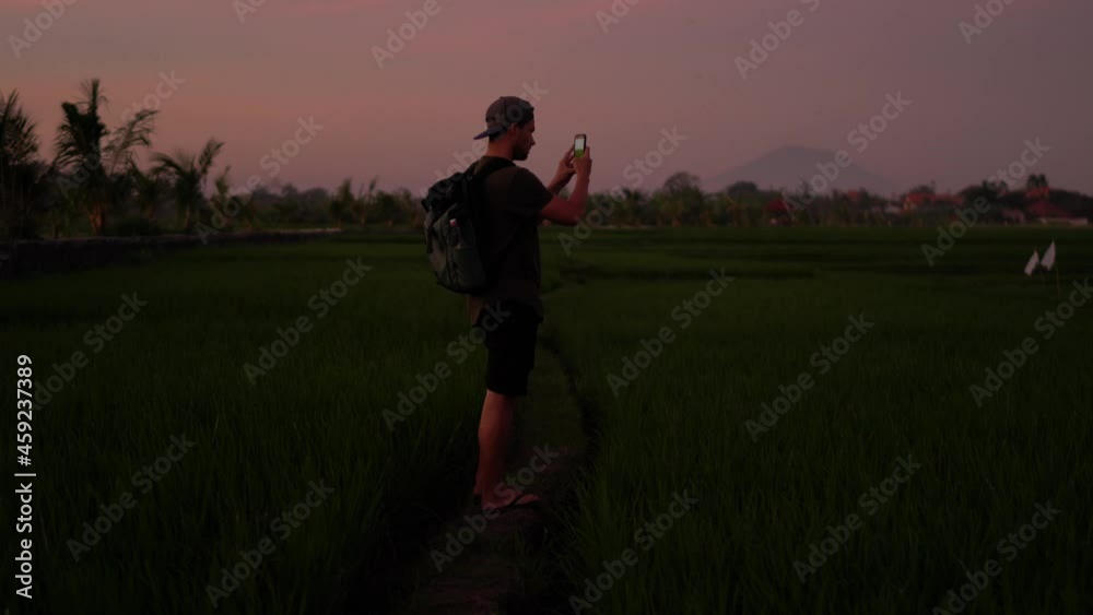 Caucasian male explorer standing on nature environment with mobile phone making video for share in social networks, hipster guy traveler taking photo via app on smartphone in evening dusk
Caucasian male explorer standing on nature environment with mobile phone making video for share in social networks, hipster guy traveler taking photo via app on smartphone in evening dusk