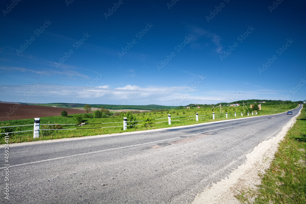 Asphalt country road along the field in spring day Asphalt country road along the field in spring day