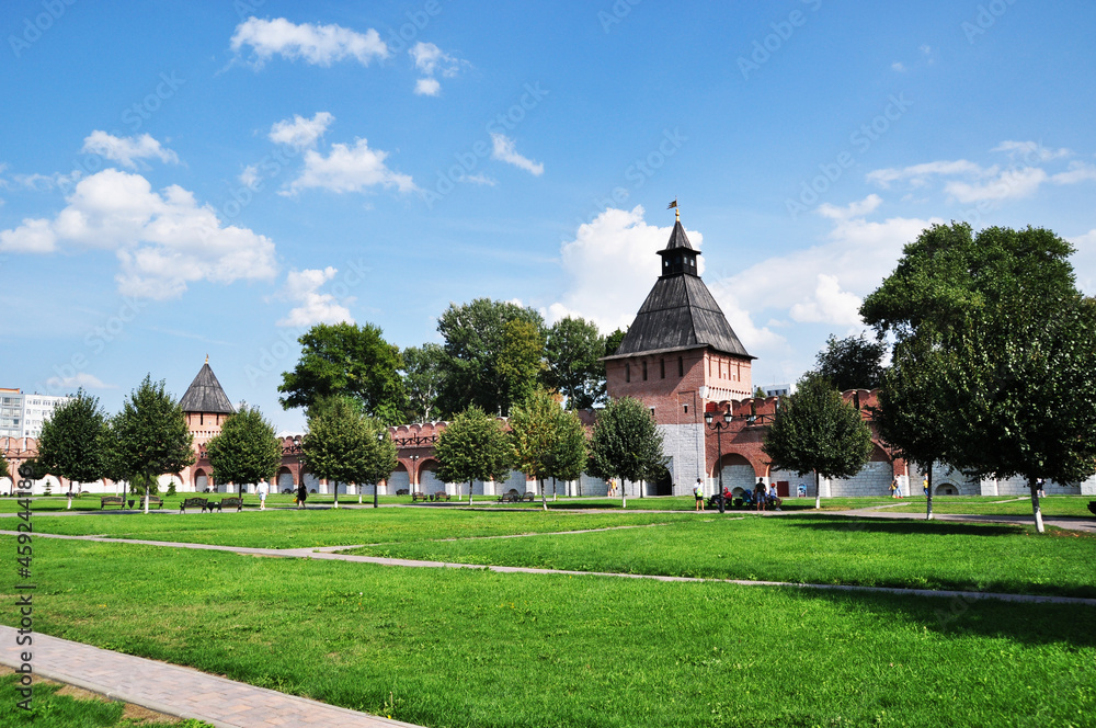 Towers of the Tula Kremlin and the fortress wall. Lawns with green grass against the background of the fortress walls.
