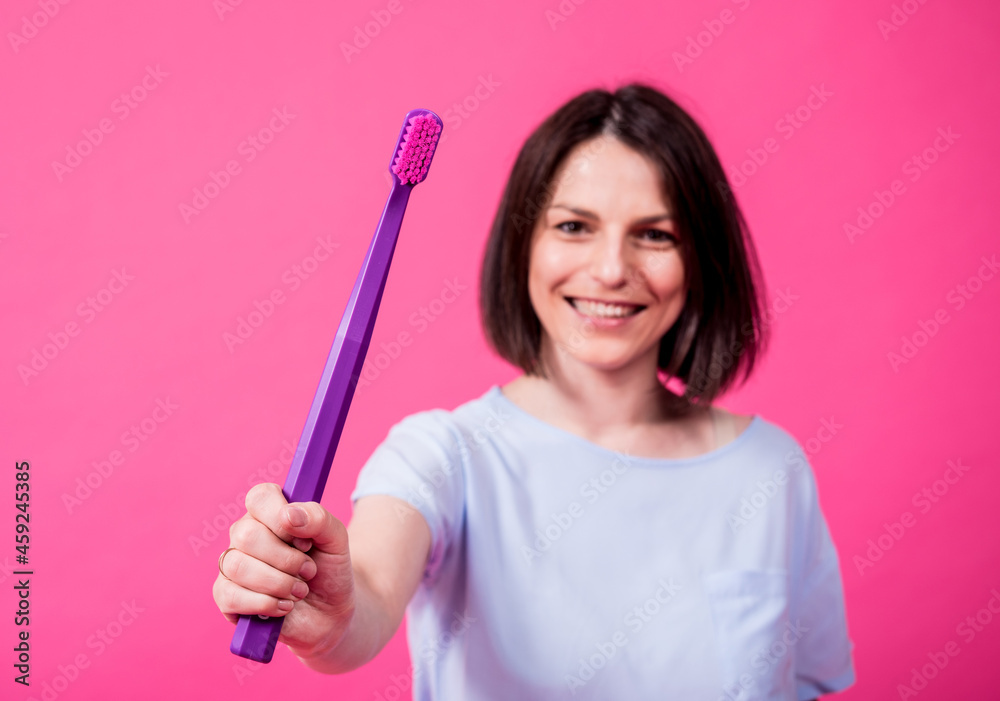 Beautiful happy young woman with big toothbrush on blank pink background Beautiful happy young woman with big toothbrush on blank pink background