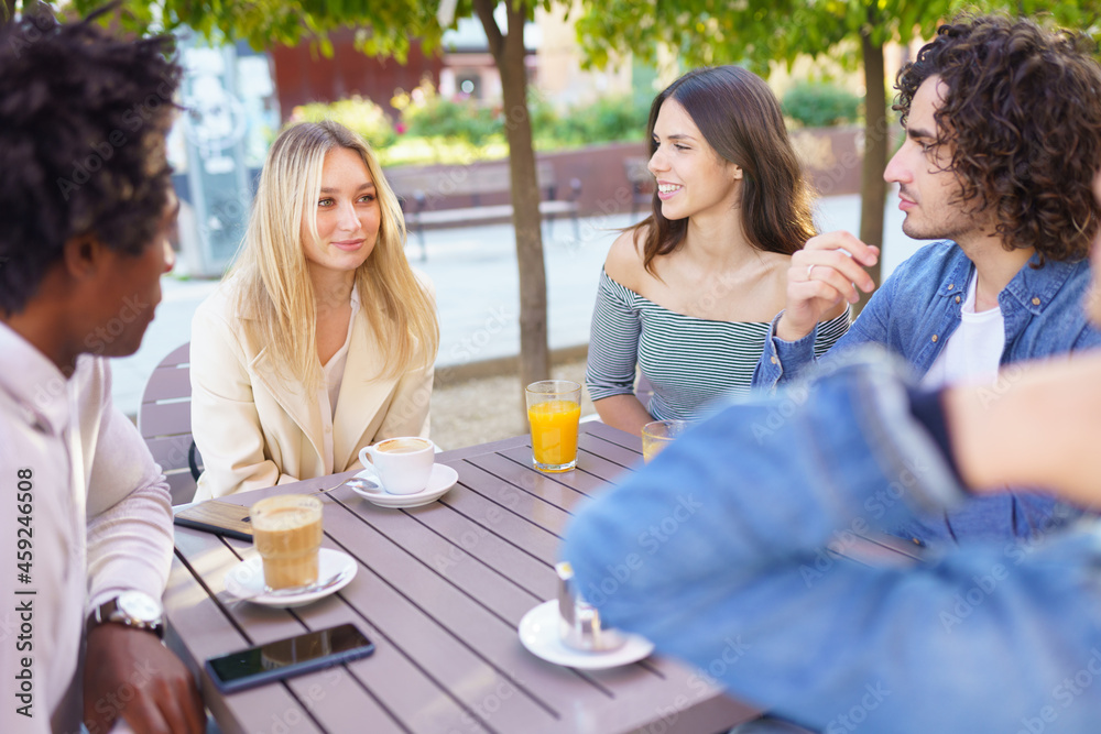 Multi-ethnic group of friends having a drink together in an outdoor bar. Multi-ethnic group of friends having a drink together in an outdoor bar.