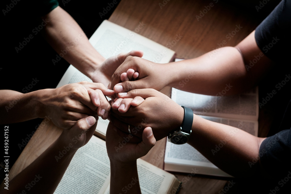 Christians are congregants join hands to pray and seek the blessings of God. Devotional or prayer meeting concept.