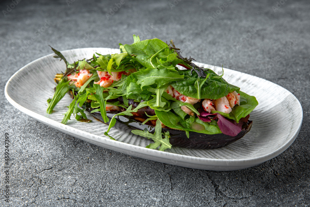 Baked eggplant with arugula, shrimps, tobiko caviar pate. Ready menu for the restaurant. Neutral gray blue textured background Baked eggplant with arugula, shrimps, tobiko caviar pate. Ready menu for the restaurant. Neutral gray blue textured background