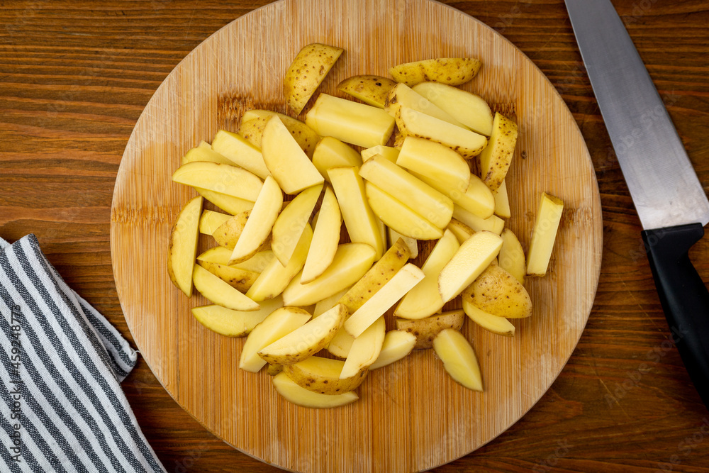 Ziemniaki ze skórką pokrojone na grube frytki. Przygotowanie szybkiej, domowej przekąski.