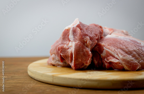 Mięso z łopatki wieprzowej bez kości. Surowe mięso leżące na drewnianej desce. Idealne mięso do gulaszu. 