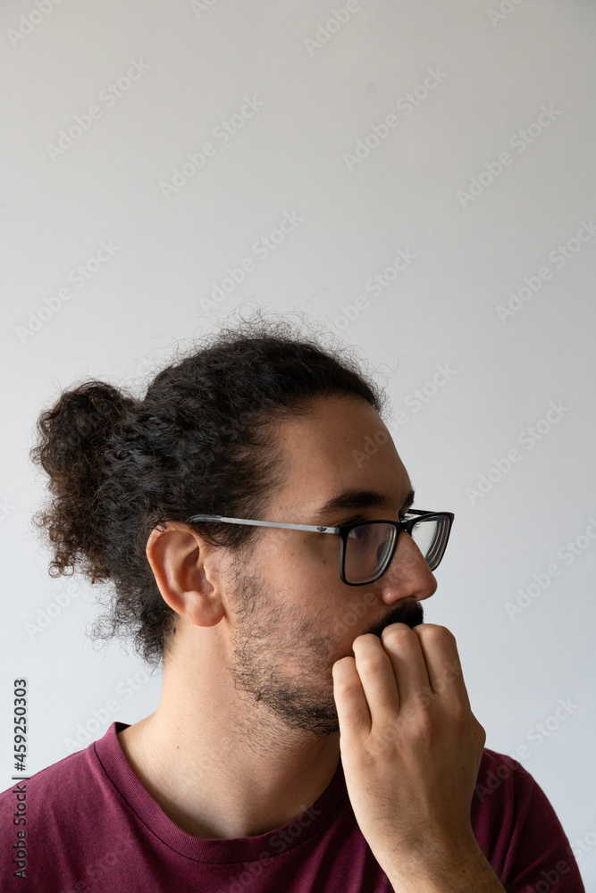 Vertical close up of distracted young man biting his nails Vertical close up of distracted young man biting his nails