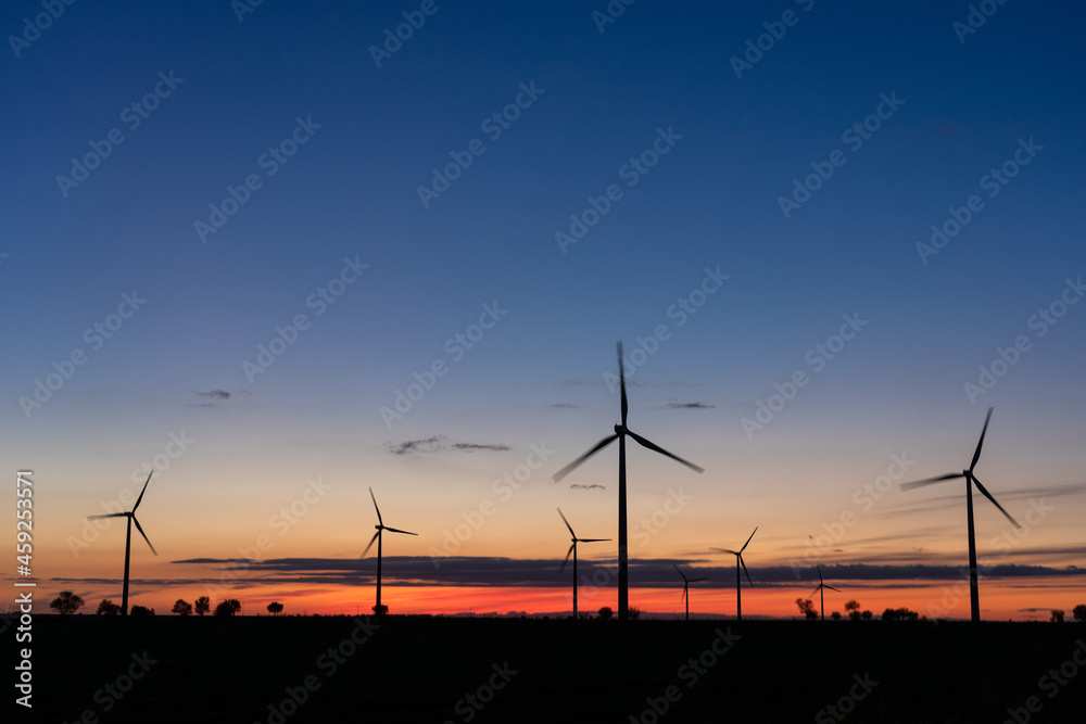 Production of electrical energy with wind mills in a sustainable way with renewable energies at sunset Production of electrical energy with wind mills in a sustainable way with renewable energies at sunset