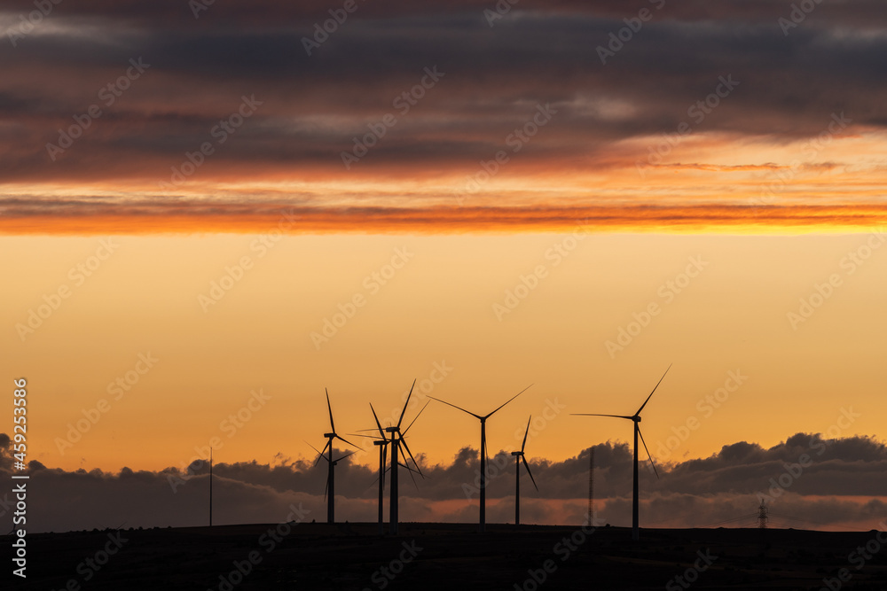 Production of electrical energy with wind mills in a sustainable way with renewable energies at sunset Production of electrical energy with wind mills in a sustainable way with renewable energies at sunset