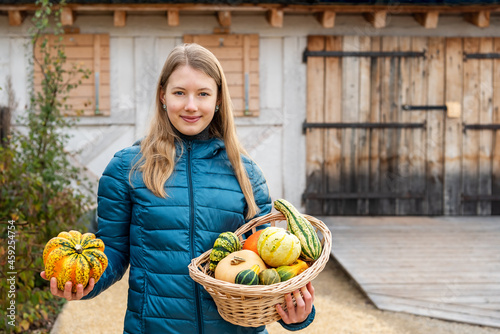 Girl in the household yard with a basket in her hands filled with fresh vegetables