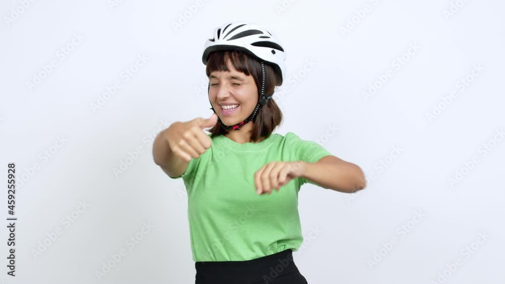 Young woman with bike helmet over isolated background giving thumbs up and smiling because something good has happened over isolated background Young woman with bike helmet over isolated background giving thumbs up and smiling because something good has happened over isolated background