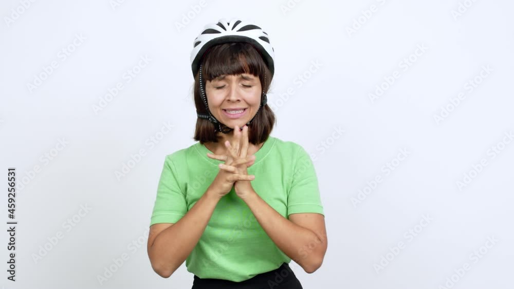 Young woman with bike helmet over isolated background with fingers crossing and wishing the best. Making a wish over isolated background Young woman with bike helmet over isolated background with fingers crossing and wishing the best. Making a wish over isolated background