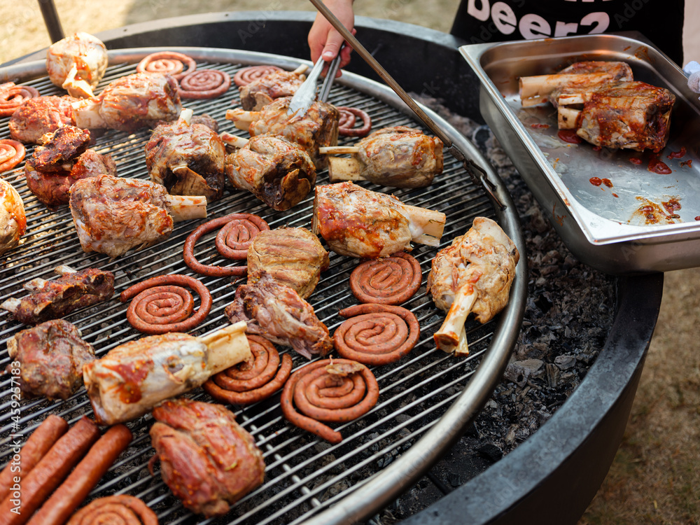 Grill cooking and roasting pork, beef, chicken meat and sausages on the picnic with barbecue. Outdoor nature background concept Grill cooking and roasting pork, beef, chicken meat and sausages on the picnic with barbecue. Outdoor nature background concept