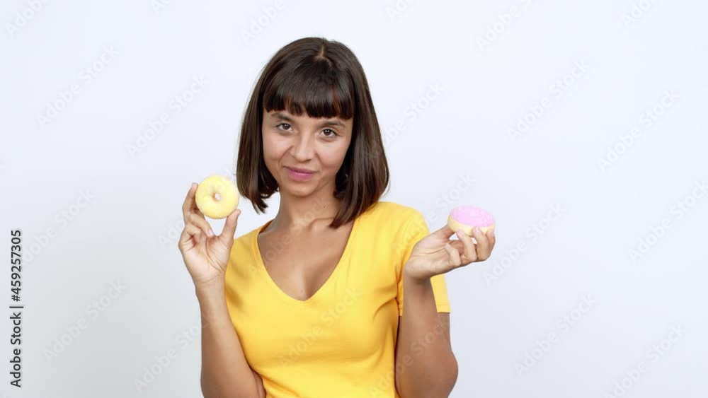 Young woman happy and holding a donut over isolated background Young woman happy and holding a donut over isolated background