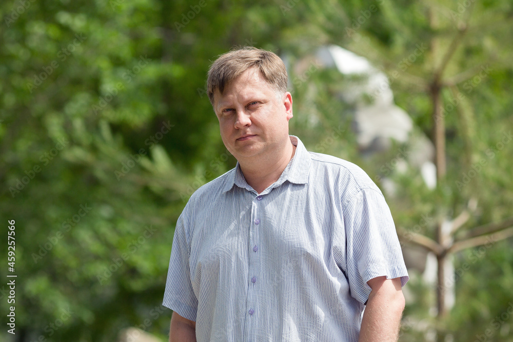 Portrait of a Caucasian man 40-45 years old in a short-sleeve shirt in hot weather.