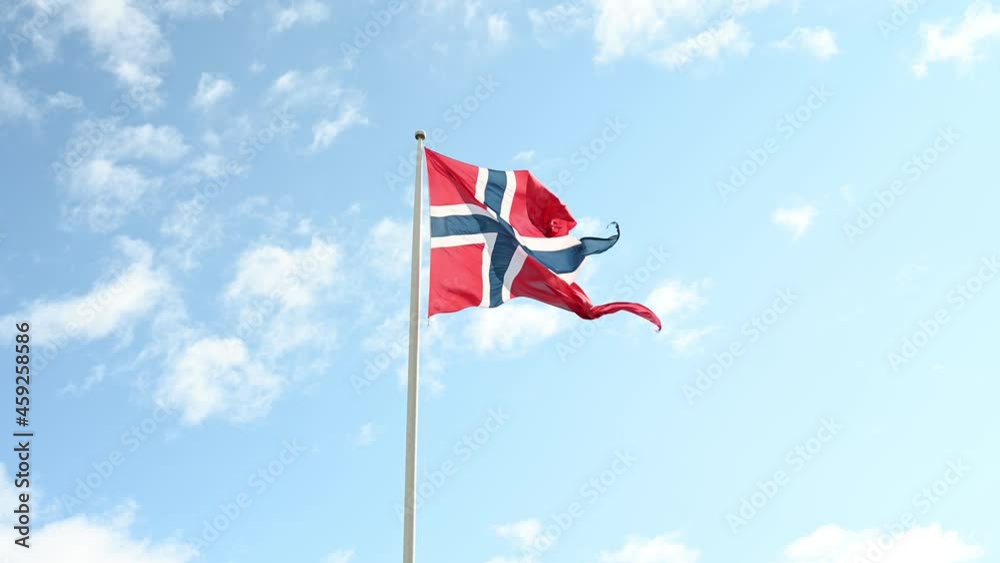 Waving national flag of Norway under a partly-cloudy sky. Waving national flag of Norway under a partly-cloudy sky.