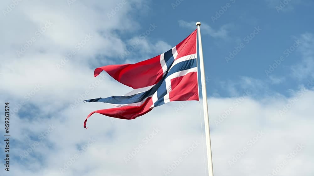 Waving flag of Norway under a partly-cloudy sky. Waving flag of Norway under a partly-cloudy sky.