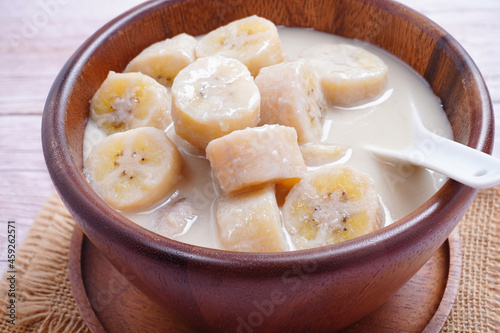 Banana in coconut milk, on a wooden cup of Thai dessert