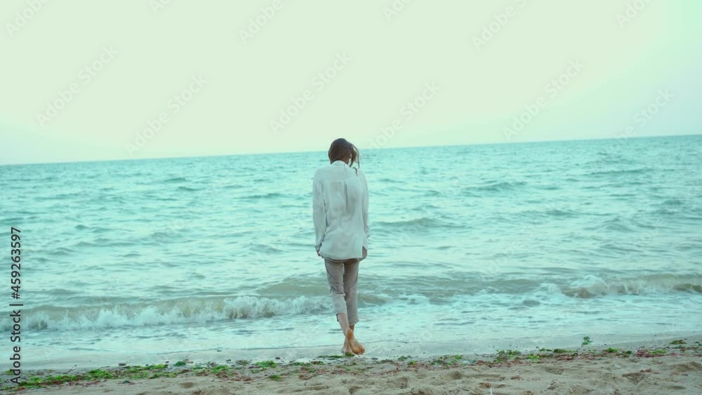 Beautiful summer woman walking in sea water with waves. Freedom and paradise concept Beautiful summer woman walking in sea water with waves. Freedom and paradise concept
