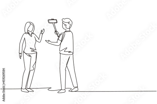 Single continuous line drawing girl makes video blog with cameraman on the street. Young woman blogger, journalist filming with smartphone and videographer. One line draw design vector illustration