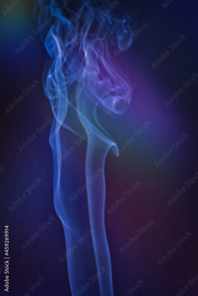A vertical shot of smoke in colorfull backlight with a blue note A vertical shot of smoke in colorfull backlight with a blue note