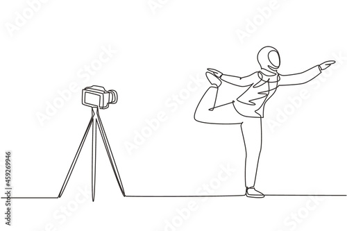 Single continuous line drawing Arab woman blogger in hijab sportswear shoots video on camera doing exercises at home. Fitness vlogger live broadcast of training session. One line draw design vector