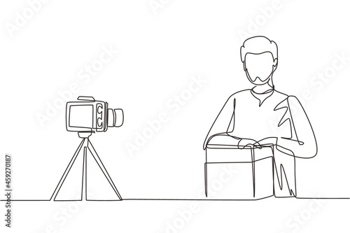 Single one line drawing Arab male vlogger unboxing  review product live on youtube in studio. Social media influencer recording unboxing video at home. Continuous line draw design vector illustration
