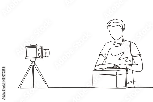 Single continuous line drawing male vlogger unbox and review product live on youtube in studio. Social media influencer recording unboxing video at home. One line draw design vector illustration
