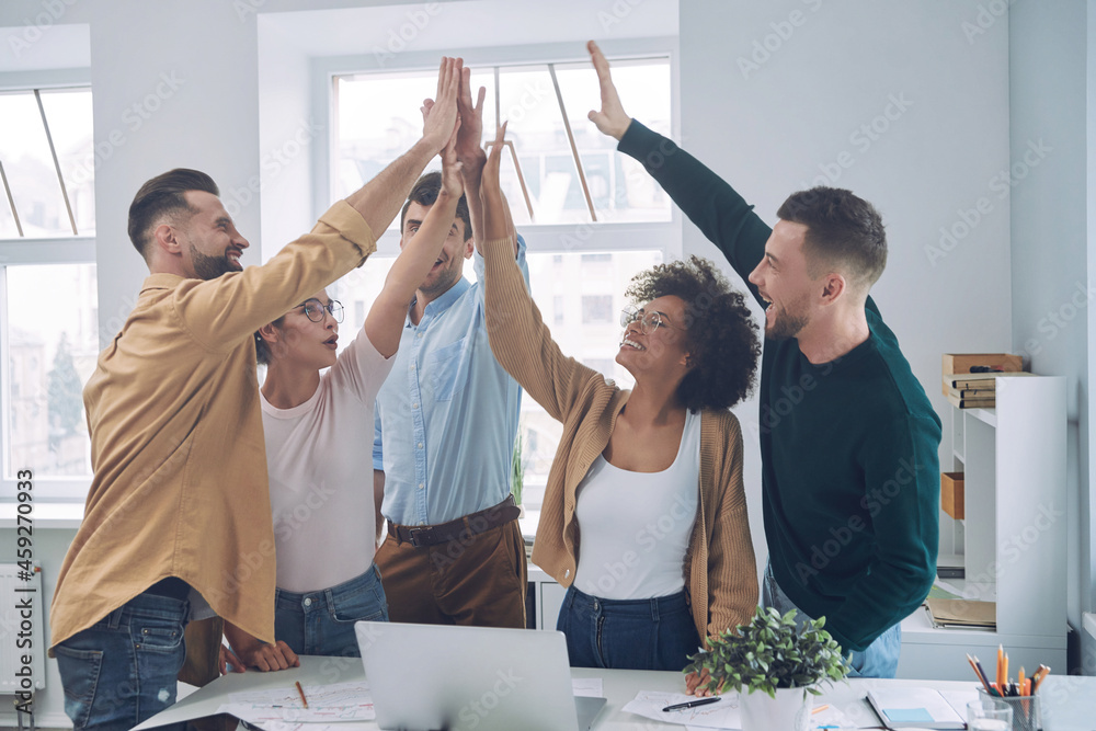 © gstockstudio - Group of happy young people in smart casual wear holding hands together and smiling © gstockstudio - Group of happy young people in smart casual wear holding hands together and smiling