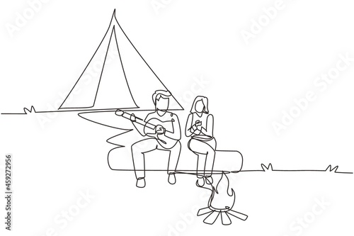 Single one line drawing couple hikers sitting on log of wood near campfire in forest. Woman drinking hot tea, man playing guitar, camping gear and backpack. Continuous line draw design graphic vector