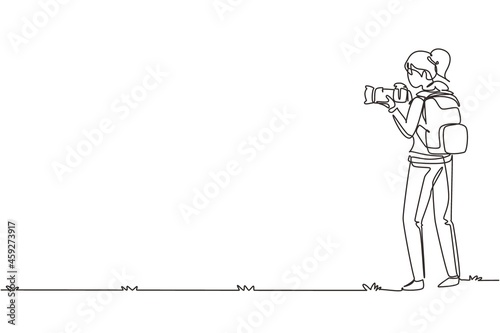 Single continuous line drawing woman photographer with backpack holding photo camera. Journalist making nature shooting on mountain. Female character. One line draw graphic design vector illustration