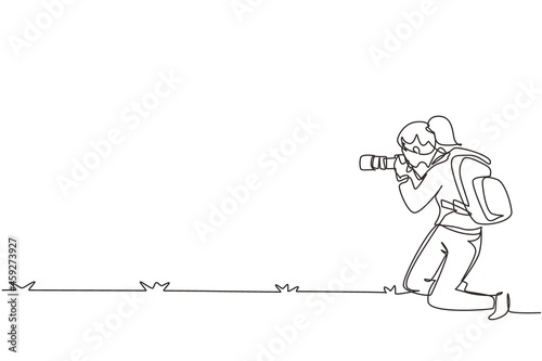 Single continuous line drawing woman photographer with backpack, standing on one knee and holding photo camera. Tourist photographing in authentic situation. One line draw design vector illustration